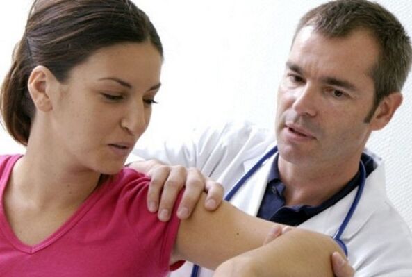 The doctor examines the shoulder with arthrosis